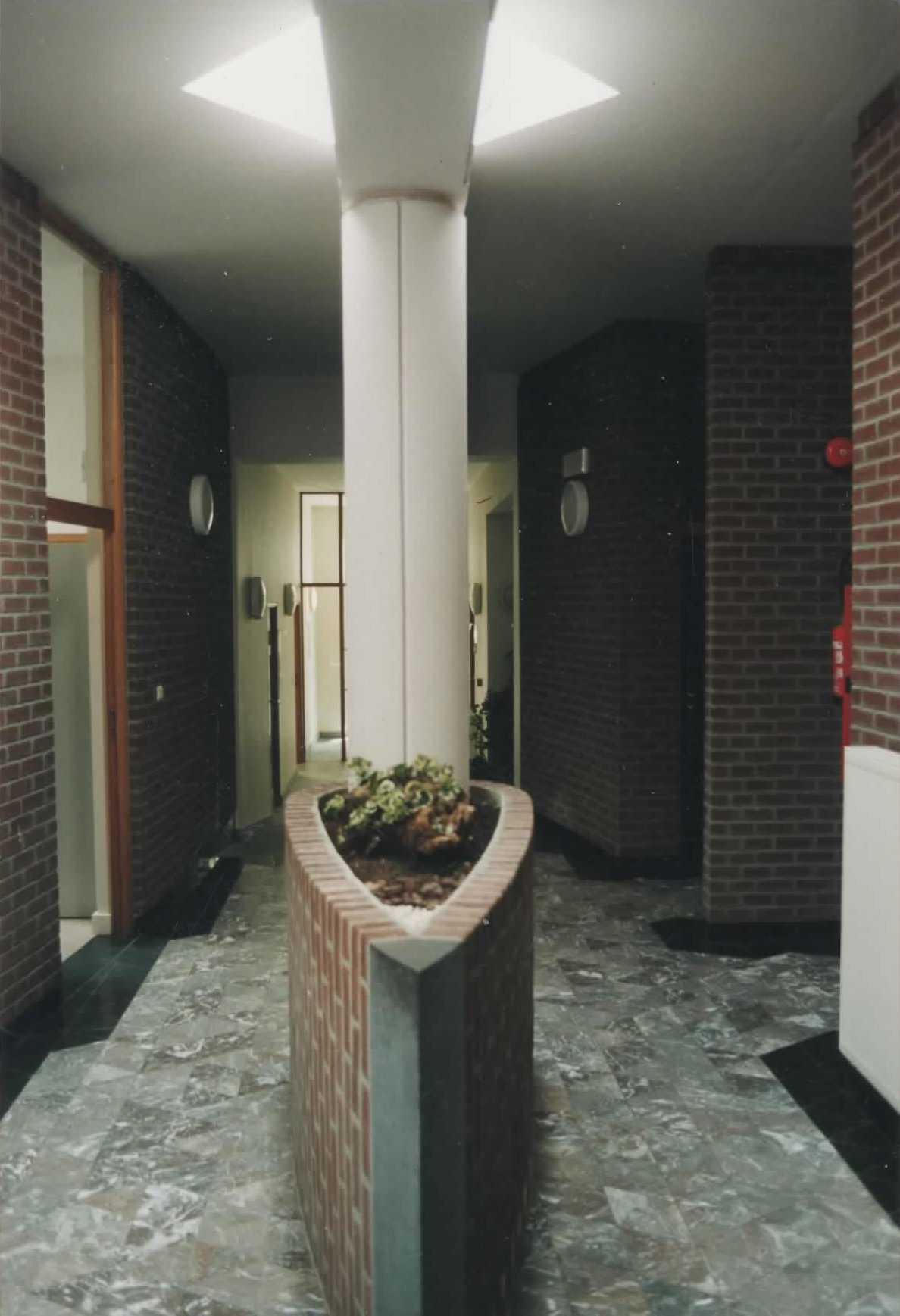 Intérieur hall avec colonne blanche et jardinière brique