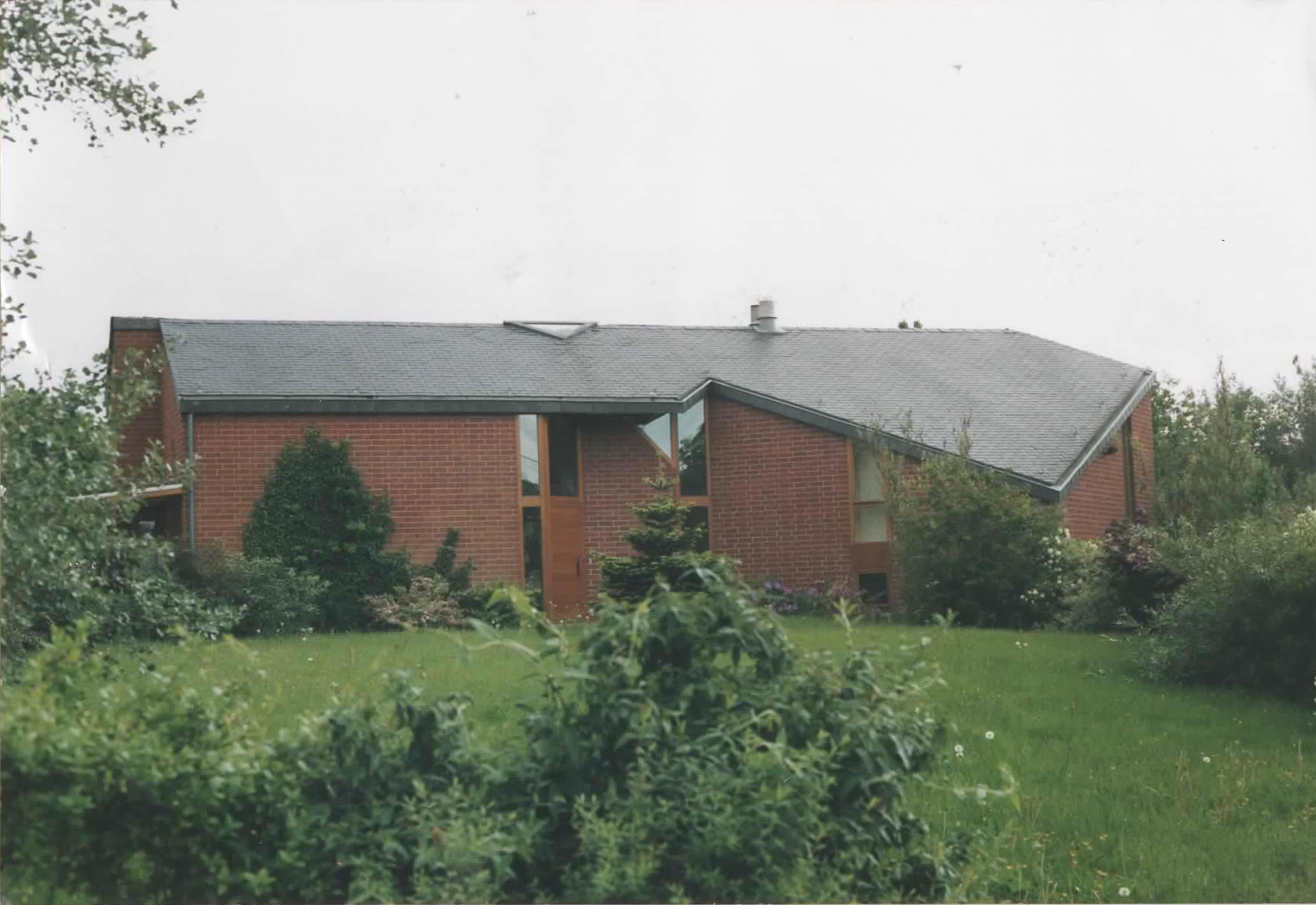 Maison en brique rouge, toiture ardoise sur jardin