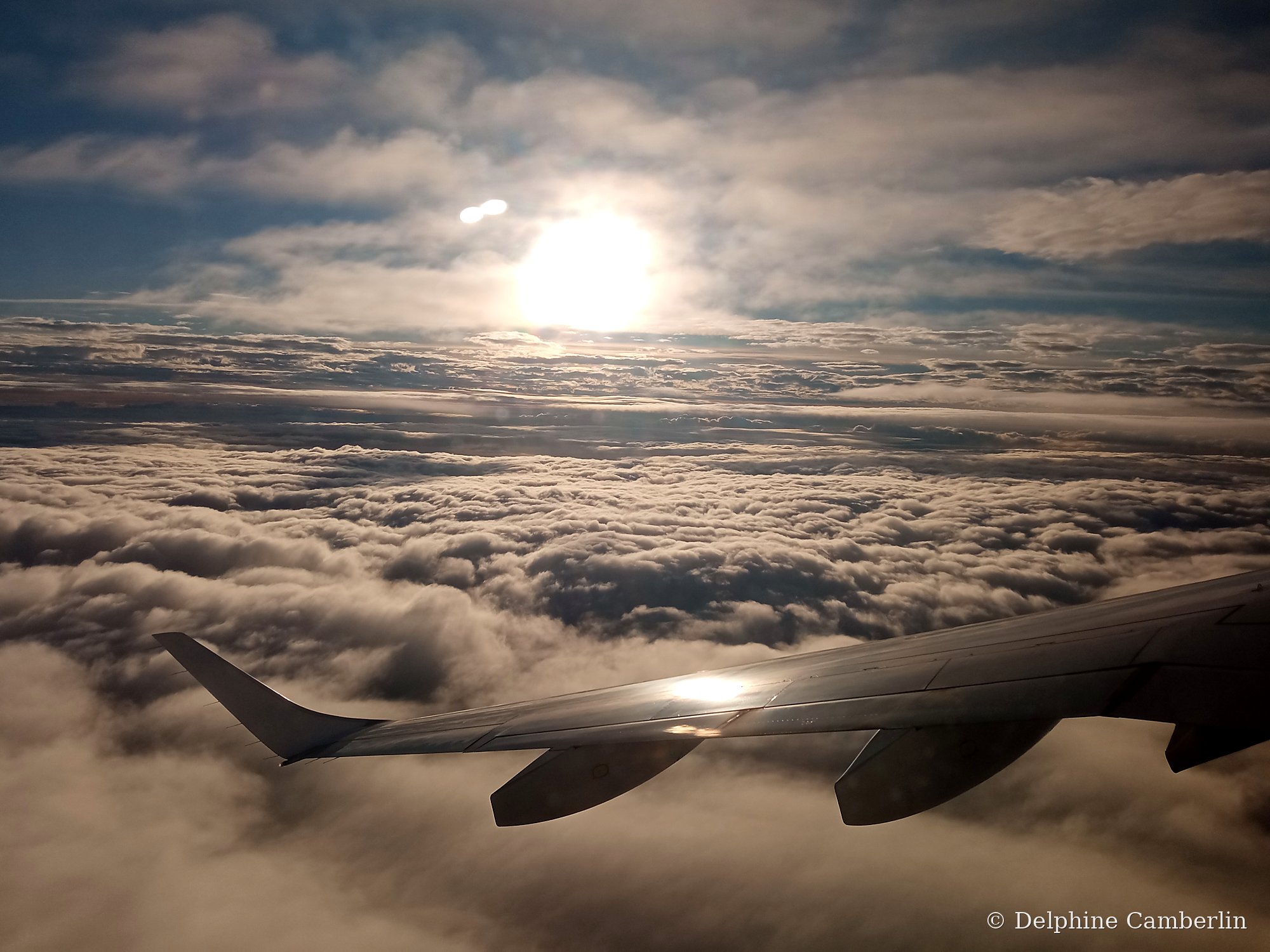 Plane wing through clouds — direct vs connecting flights
