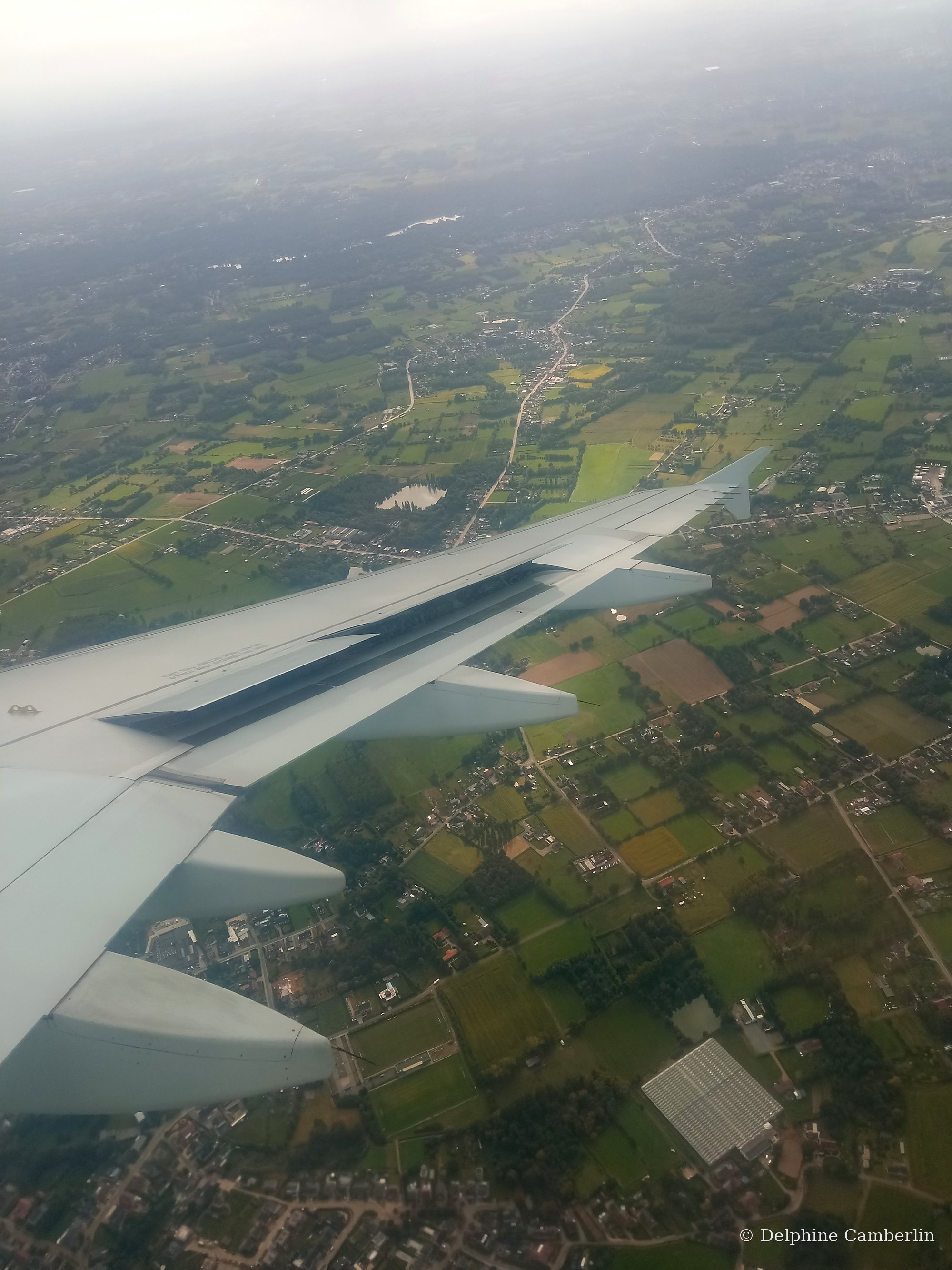 Plane wing over rural Indonesia — reforestation offset projects