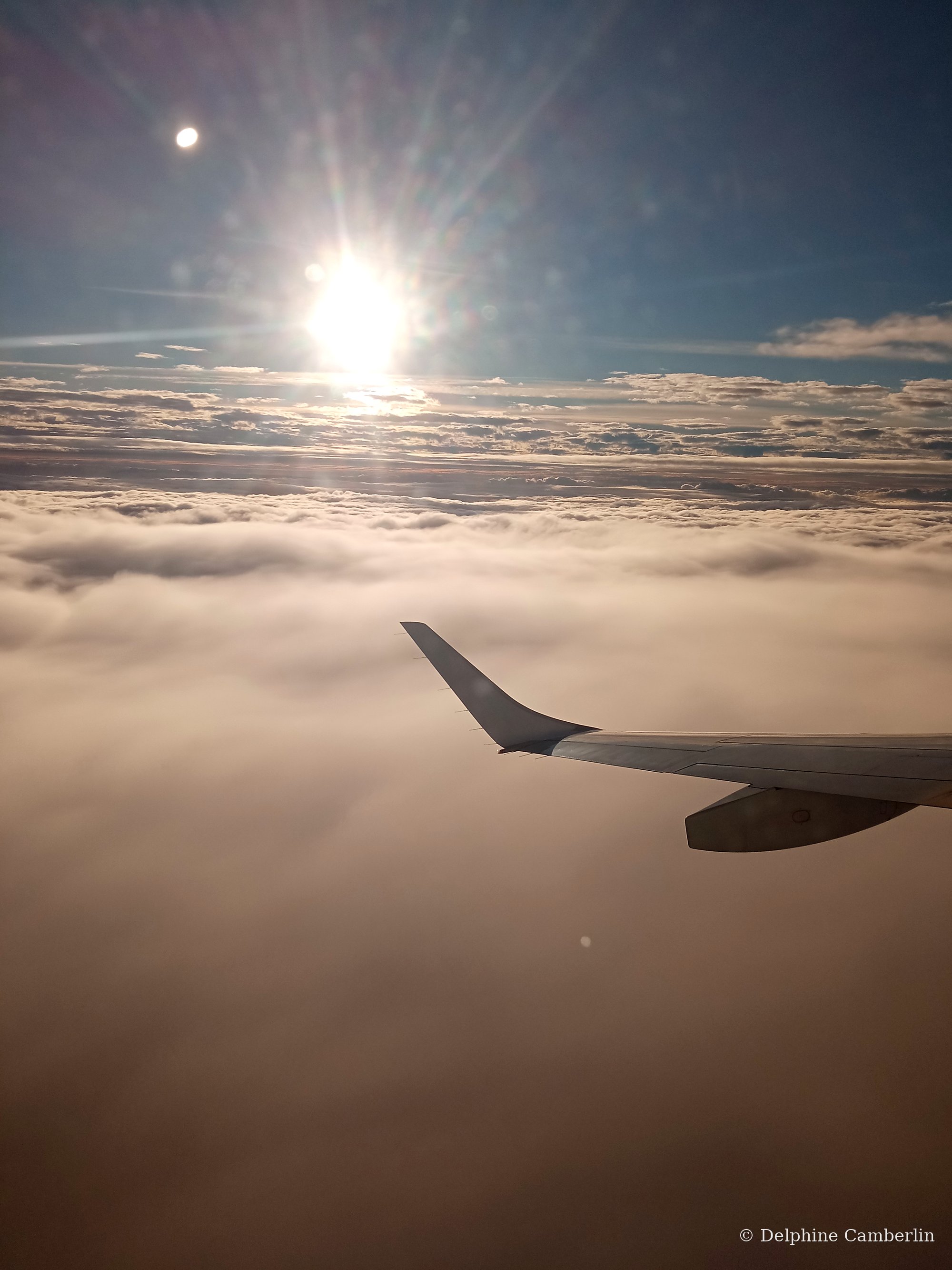 Plane wing above clouds — radiative forcing multiplier