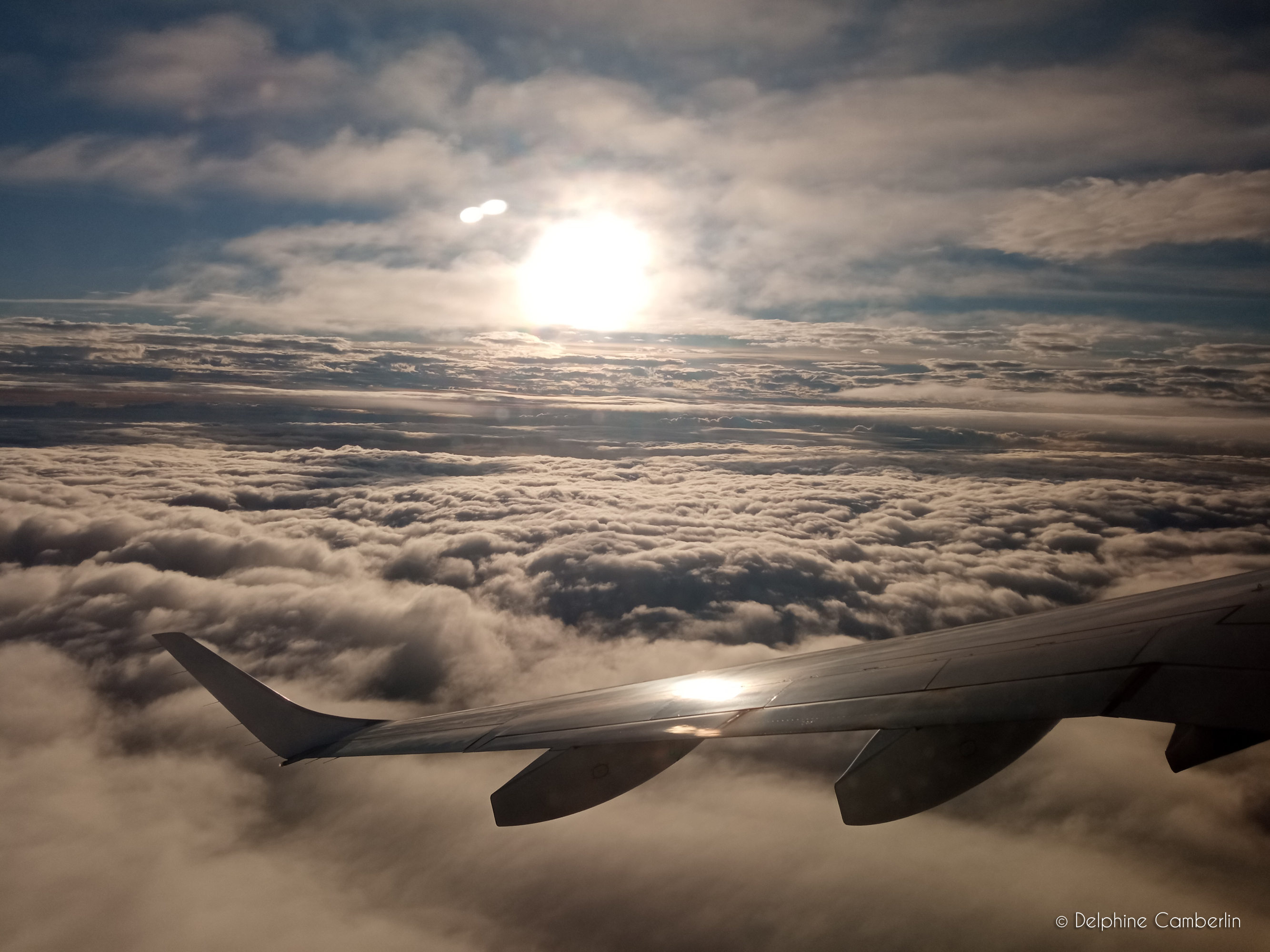 Rain drops on an airplane window at the airport with a plane visible behind — flight delays and disruptions are exactly what travel insurance is for
